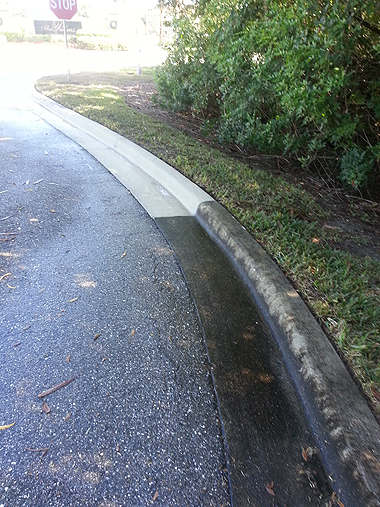Before and after pressure washing of a curb